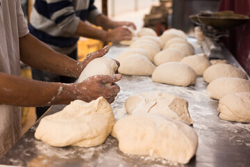 Male hands knead yeast dough for baking bread