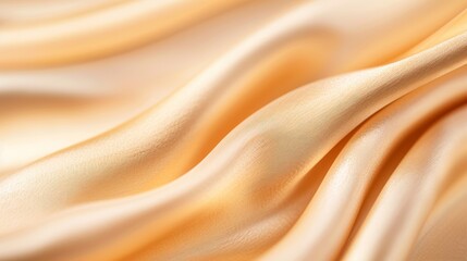 Fototapeta premium Soft, silky fabric in warm peach hues creating a flowing and elegant texture, perfect for backgrounds or fashion designs.