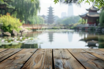 Fototapeta premium Empty wood table top and a blurred Chinese zen garden with a pond and ancient temple in the background, for displaying or mounting your products