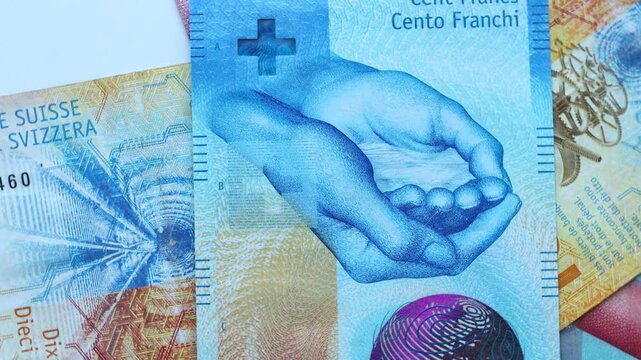 Swiss francs spinning around its own axis. More banknotes thrown into the financial carousel, The concept of financial turmoil in Switzerland