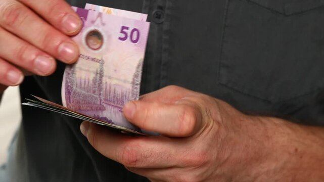 Mexican pesos counted in hand. Mexico money, financial concept