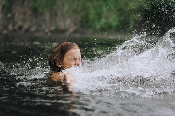 Obraz premium Little happy girl, smiling child jumping, having fun, laughing, spinning, swimming in water on the sea, in the lake. Photo, portrait.