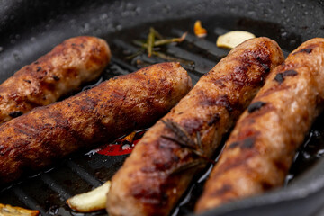 Fried sausages in a frying pan close-up
