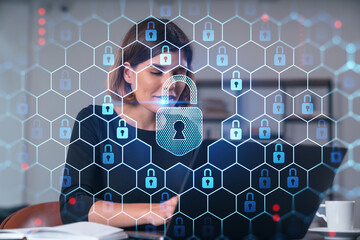 Woman working on a laptop with a digital lock overlay for cybersecurity concept.