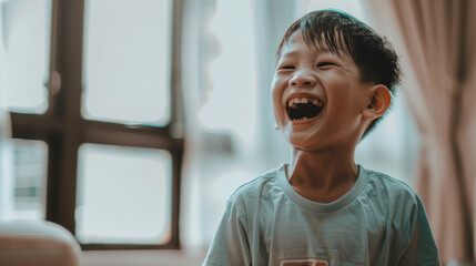A young boy with a joyful expression, captured in a candid moment of pure laughter inside a warmly-lit room.