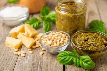 Pesto. Italian basil pesto sauce on a textured wooden background. Ingredient for pesto sauce: fresh...