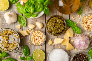 Pesto. Italian basil pesto sauce on a textured wooden background. Ingredient for pesto sauce: fresh...