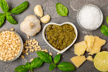 Pesto. Italian basil pesto sauce on a textured wooden background. Ingredient for pesto sauce: fresh...