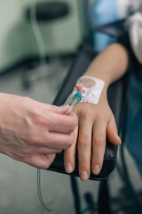 Close-up of a healthcare worker connecting an IV infusion set for venous access during medical treatment