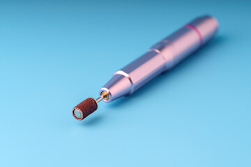 nail machine with a grinding bit on a blue background