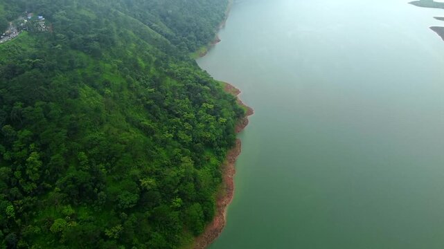 Aerial view of umiam lake serene blue water with misty mountains aerial image is taken at umiam lake shillong meghalaya india. it is showing the breathtaking beauty of nature.