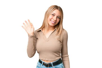 Young pretty blonde woman over isolated chroma key background saluting with hand with happy expression