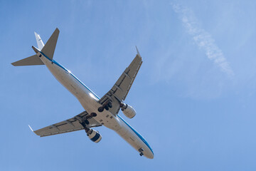 Landing airplane on the background of blue sky