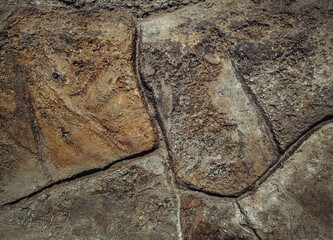 The texture of natural stone of a reddish-dirty brown color in wall or floor cladding. Concrete imitation.