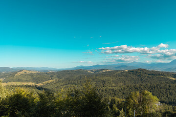 Scenic Mountain Landscape Under Clear Sky. A panoramic view of a lush green mountain landscape under a clear blue sky.
