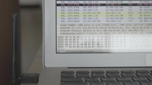 A laptop screen shows a lot of numbers and letters. The laptop is open to a page with a lot of information