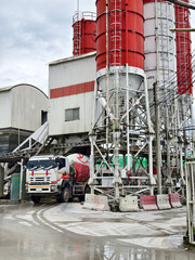 Naklejka premium A concrete mixer truck is stationary outside of a concrete factory