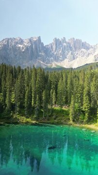 Der wundersch&ouml;ne Karersee (Lago di Carezza) mit einer m&auml;chtigen Bergkulisse im Hintergrund in den Dolomiten