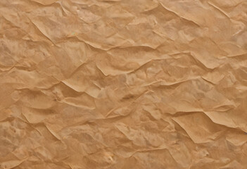 Obraz premium A textured background featuring crumpled, wrinkled paper in warm beige tones. The surface has a natural, organic feel, ideal for artistic or design purposes.