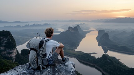 Fototapeta premium Solitude at Sundown: Lone Backpacker Admiring Sunset Horizon from Mountain Top - Concept of Serenity and Adventure