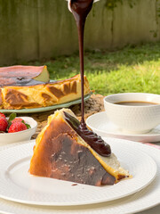 Popular Spanish cheesecake called San Sebastian cheesecake., Sliced san sebastian cheesecake with coffee on table