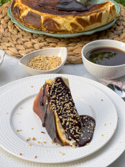 Fototapeta premium Popular Spanish cheesecake called San Sebastian cheesecake., Sliced san sebastian cheesecake with coffee on table