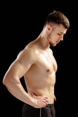 Serious athletic man posing showing his muscles on black background