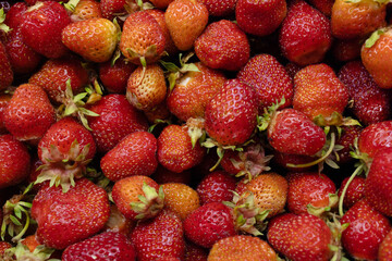Fresh strawberries with vibrant green leaves are beautifully arranged for market display and culinary uses