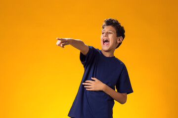 Kid boy mocking and teasing at someone showing finger at camera. Bulling concept © Aleksej