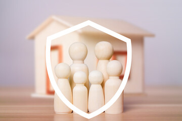 A wooden model family standing in a protective shield, symbolizing the love and security that family members give to each other, with a model house. Insurance and life insurance concept for families.