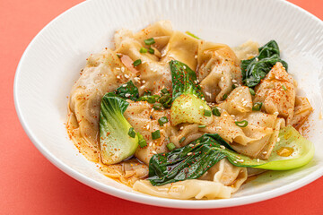 Portion of appetizing asian wonton dumplings with bok choi