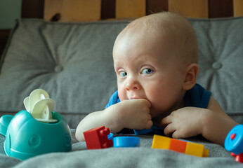 A baby is playing with a toy car and blocks