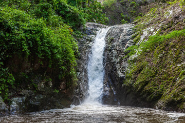 Waterfall in Chae Son National Park, Thailand. Water stream is falling off the cliff in tropical...