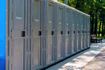 unique line of plastic portable toilets stretches along the boulevard, blending practicality with urban aesthetics, highlighting the balance between functionality and outdoor leisure