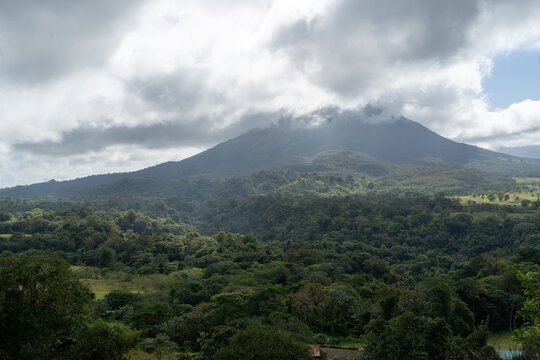 View of volcano in Costa Rica in the clouds, with rain forest in the foreground