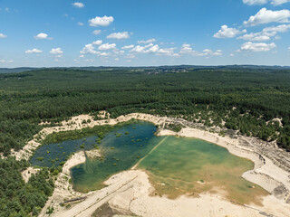 Aerial drone view of flooded sand pit. An artificial lake after a flooded sand pit. Forest submerged in a lake. Sunken sandpit with crystal clear water in Klucze, Poland.