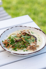 Squash fritters with wild mushrooms chanterelles in sour cream sauce