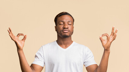 Fototapeta premium Zen. Relaxed Black Man Meditating Standing Over Yellow Background In Studio. Panorama