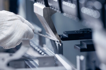 Operator working on automatic hydraulic press for bending metal sheets in industrial production....