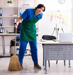 Male handsome professional cleaner working in the office