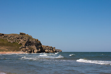 foaming waves on a sandy beach. Seascape with rocks and stones in the water