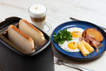 Breakfast on the table. Fried eggs, toast and latte.