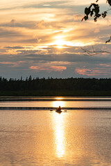 Naklejka premium Kayak fishing on peaceful lake at sunset