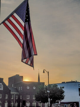 an American Flag with a sunrise behind a building in downtown Fayetteville, North Carolina