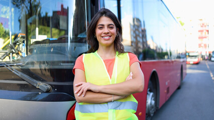 Portrait of a young female bus driver, standing proudly in front of her bus © PeopleVideos