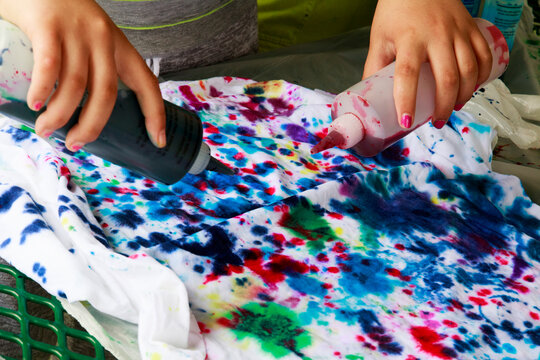 Dye applied for tie-dying on white tee-shirt.