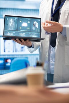 In a treatment center, healthcare experts discuss recovery strategies. Licensed doctors analyze heart and brain x rays from hospital records, focusing on diagnostics and disease prevention.