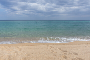 Serene Tropical Beach with Turquoise Waters and Cloudy Sky