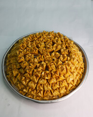 A white plate holds two delicious Turkish baklava rolls, generously filled with nuts and topped with pistachios.
