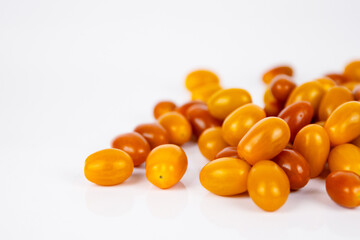 Fototapeta premium Vibrant cherry tomatoes spread on a white background. Ideal for food photography and healthy eating content, culinary websites and recipe blogs. Copy Space. Selective focus..